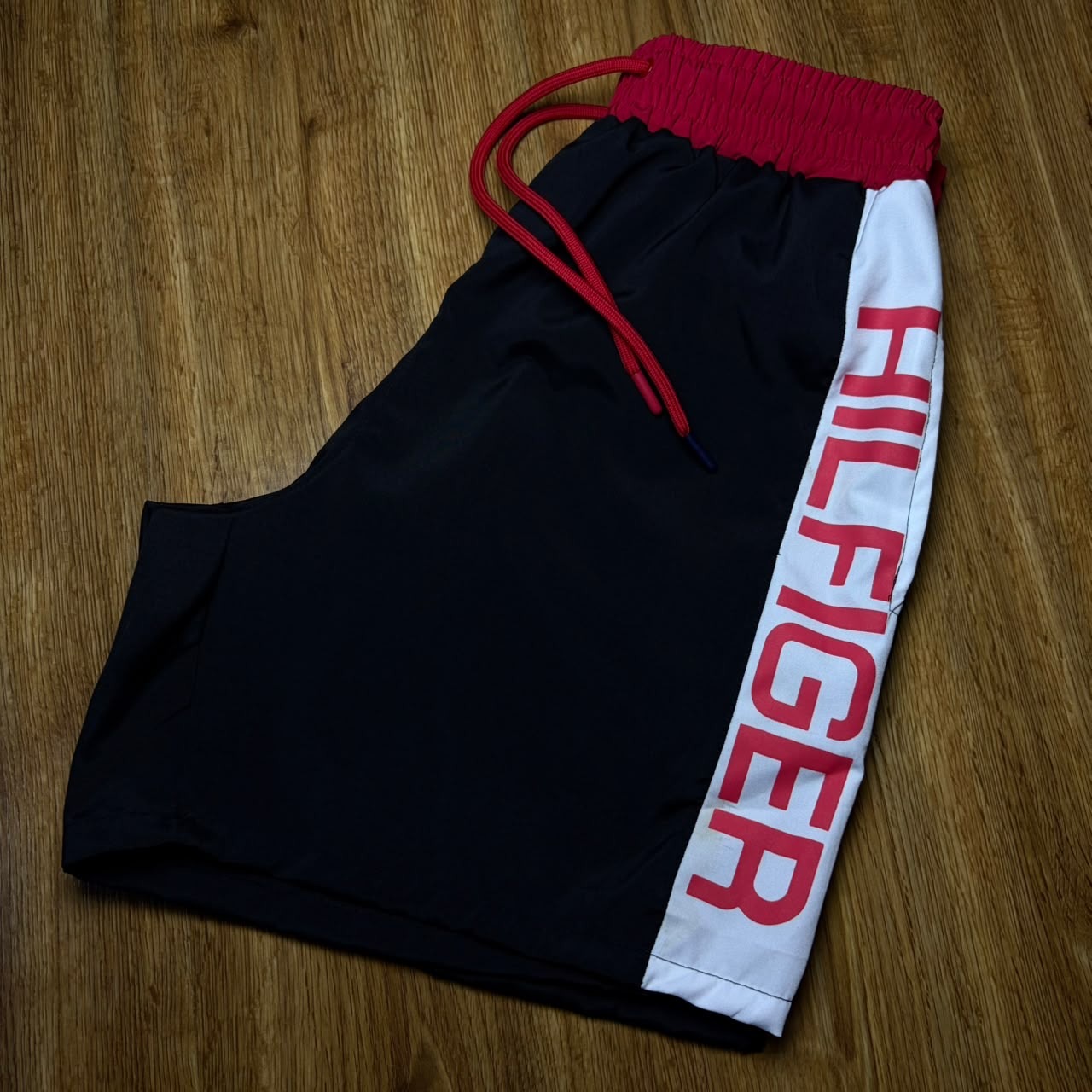 Short Tommy Hilfiger — Preto · faixa lateral branca e vermelha